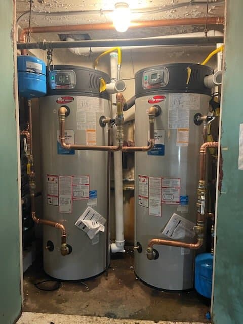 Pair of aging storage tank water heaters in a Honolulu utility closet ready for replacement — Alpha Omega Plumbing